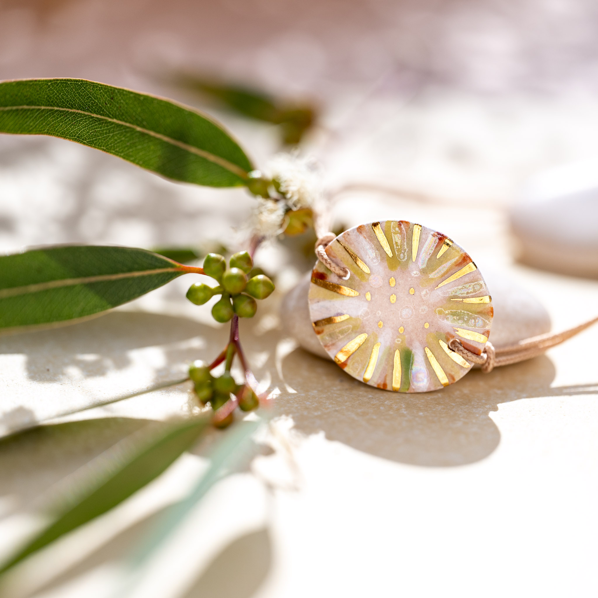 La danse avec la matière : bracelet vert Cala Gioia en harmonie avec une feuille d'eucalyptus, une célébration du geste artisanal et des nuances végétales méditerranéennes.