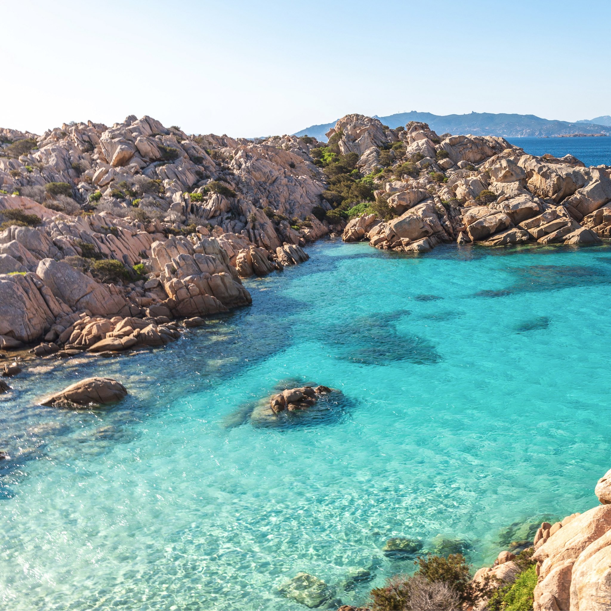Vue aérienne d'une crique méditerranéenne aux eaux translucides, véritable 'Cala' qui a inspiré le nom et l'univers de notre marque Calagioia.