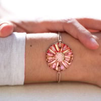 Bracelet porté au poignet en céramique rouge et orange, doré à l'or fin - Modèle Corail Mordoré - Cala Gioia