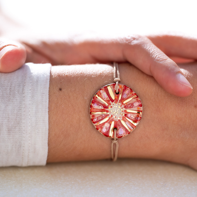 Bracelet porté au poignet en céramique rouge et orange, doré à l'or fin - Modèle Corail Mordoré - Cala Gioia
