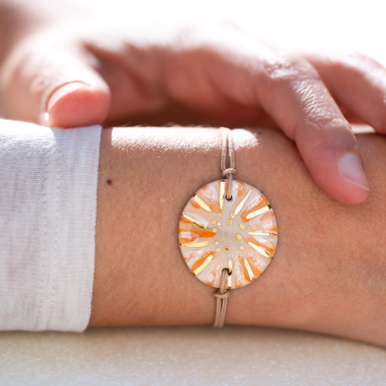 Bracelet porté au poignet en céramique orange et blanc, doré à l'or fin - Modèle Cornaline Sablée - Cala Gioia