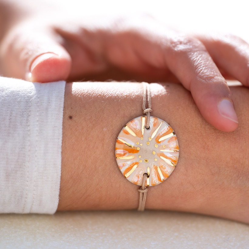 Bracelet porté au poignet en céramique orange et blanc, doré à l'or fin - Modèle Cornaline Sablée - Cala Gioia