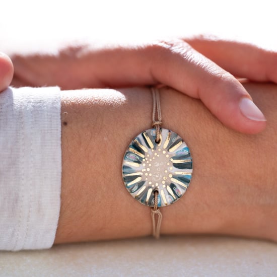 Bracelet porté au poignet en céramique gris bleu, doré à l'or fin - Modèle Écume Argentée - Cala Gioia