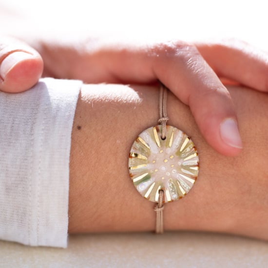 Bracelet porté au poignet en céramique vert clair, doré à l'or fin - Modèle Feuillage Irisée - Cala Gioia