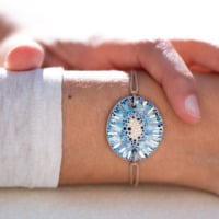 Bracelet porté au poignet en céramique bleu lagon, doré à l'or fin - Modèle Lagune Dorée - Cala Gioia