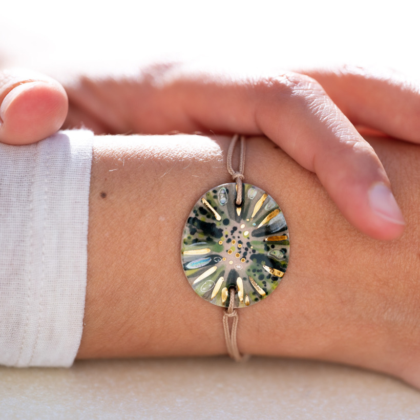 Bracelet porté au poignet en céramique vert foncé (algues, mousses), doré à l'or fin - Modèle Oxygène Perlé - Cala Gioia