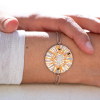 Bracelet porté au poignet en céramique orange et bleu, doré à l'or fin - Modèle Promesse d'été - Cala Gioia