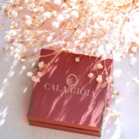 Mise en scène de notre écrin signature Cala Gioia près d'une branche de gypsophile. Une élégante boîte terracota dans laquelle chaque bijou est soigneusement emballé.