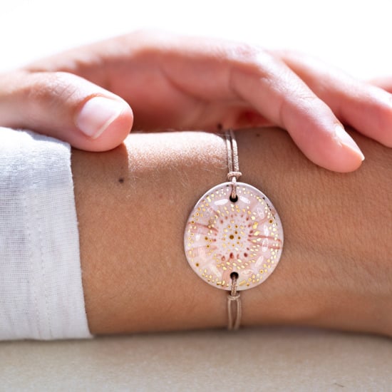 Bracelet porté au poignet en céramique blanc et beige, doré à l'or fin - Modèle Douce Clarté - Cala Gioia
