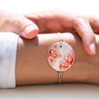 Bracelet porté au poignet en céramique rouge corail et orangé, doré à l'or fin - Modèle Fleur de Grenadier - Cala Gioia