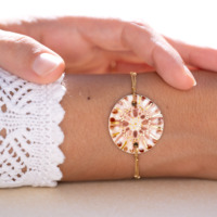 Bracelet porté au poignet en céramique terre cuite et beige, doré à l'or fin, sur chaîne perlée or laminé - Modèle Corolle Ambrée - Cala Gioia