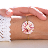 Bracelet porté au poignet en céramique rose et rose pâle, doré à l'or fin, sur chaîne perlée or laminé - Modèle Tendresse Nacrée - Cala Gioia